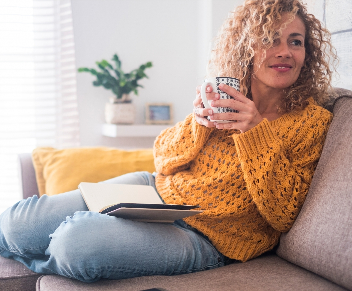Woman relaxing at home while reviewing credit card and balance transfer options