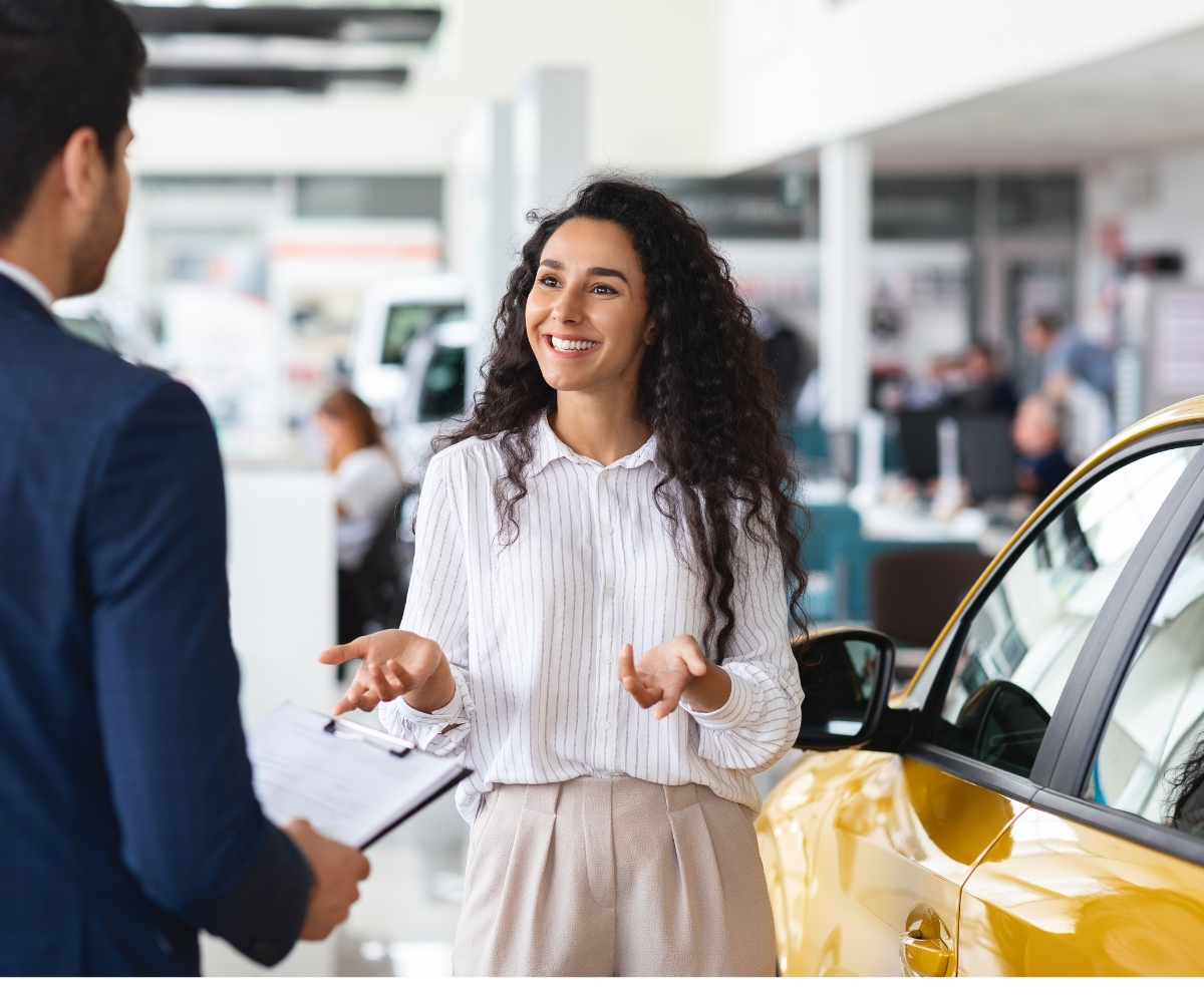 Woman discussing auto loan options with a dealership representative