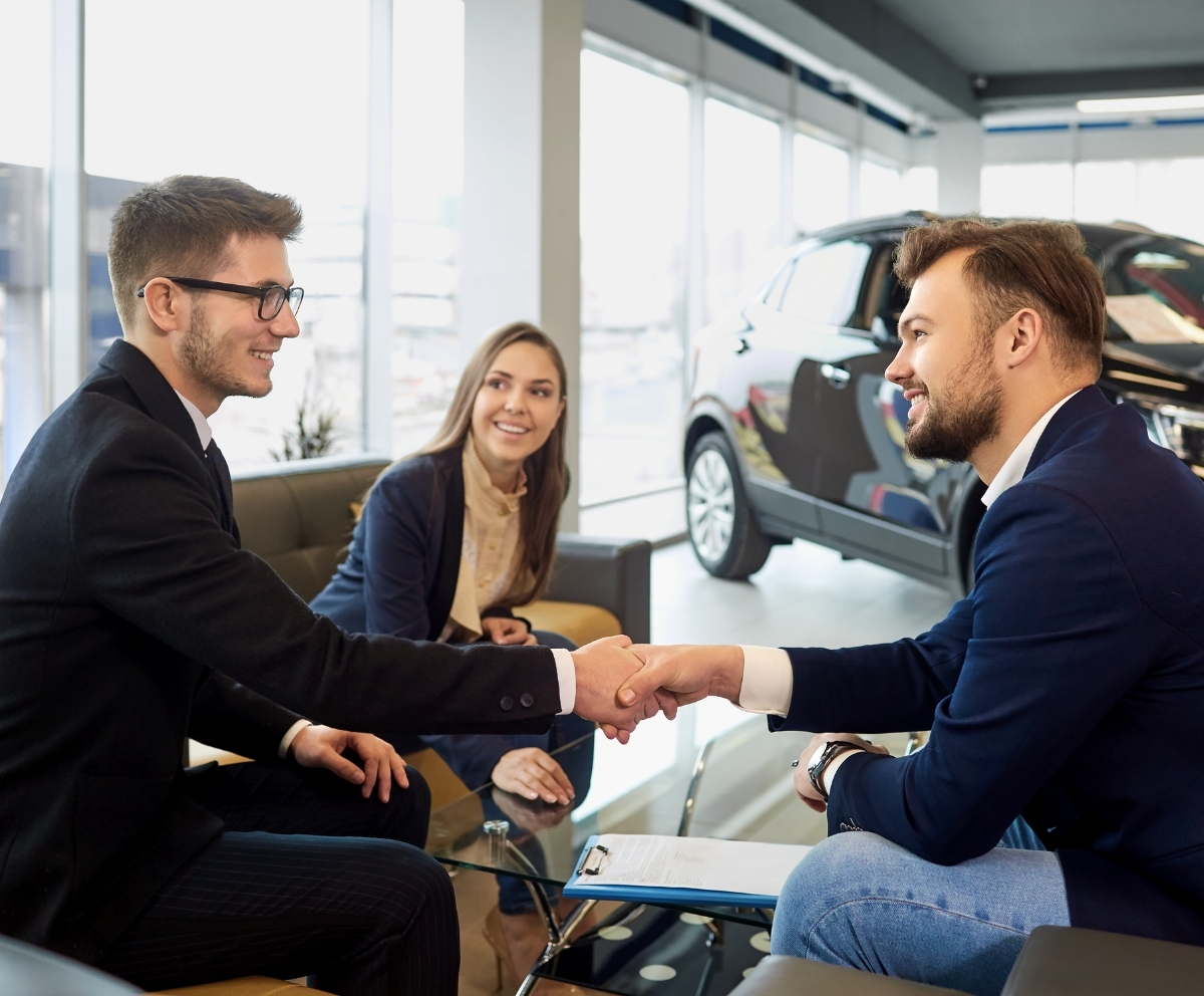 Car buyer shaking hands with dealership representative after discussing GAP coverage