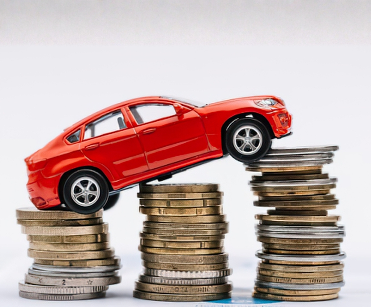 Toy car on stacks of coins representing vehicle value and depreciation