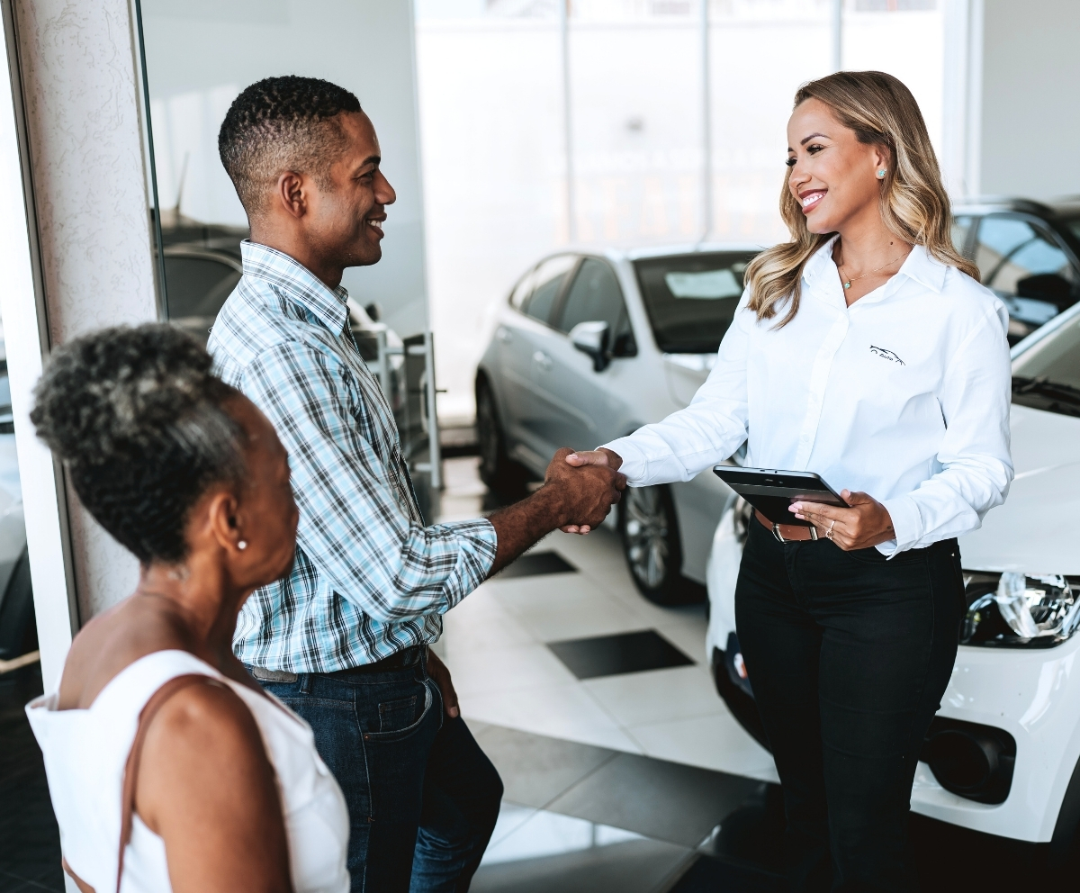 Car buyer shaking hands with a dealership representative after discussing vehicle protection