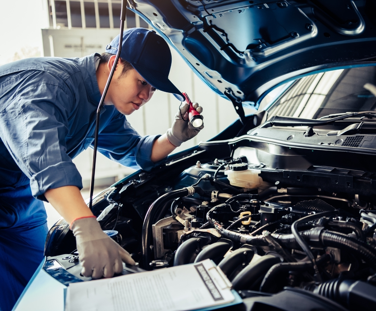 Mechanic inspecting an engine during a covered vehicle repair