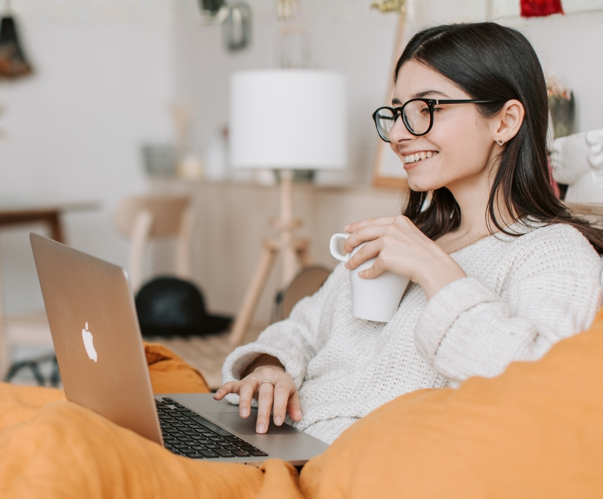 Woman using a laptop while reviewing Certificate of Deposit savings options