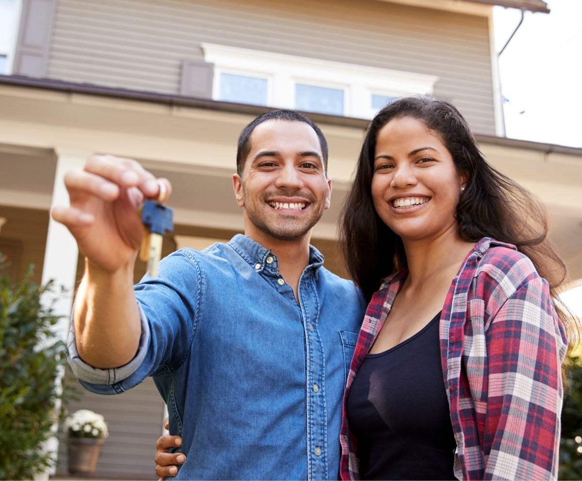 Couple holding house keys after buying a home with mortgage support
