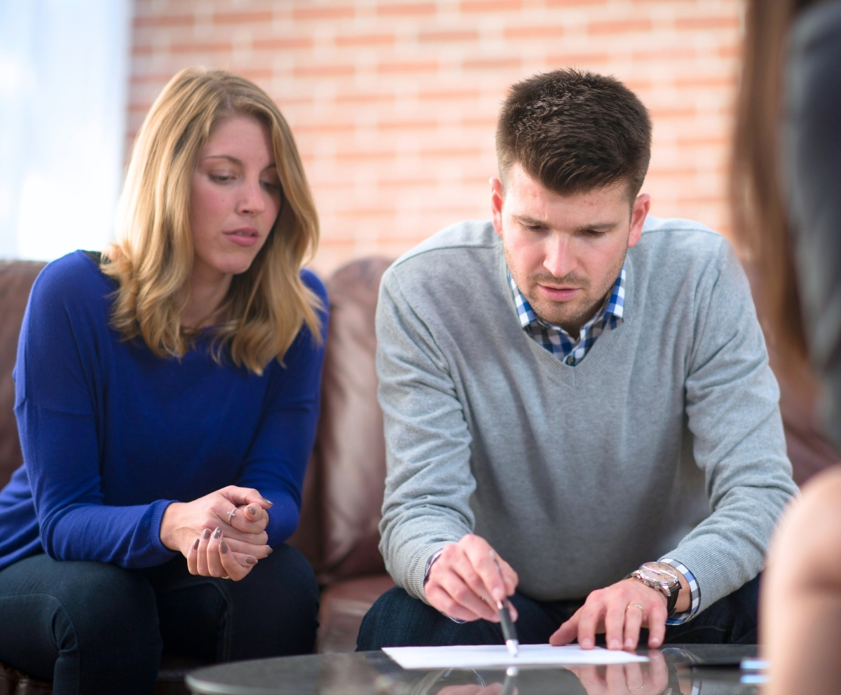 Couple reviewing home loan paperwork with a mortgage professional