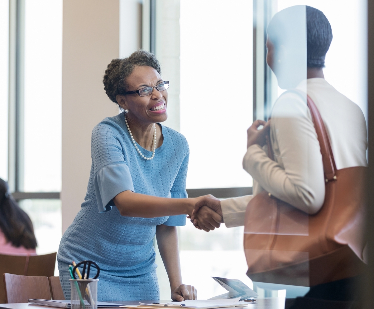 Two people shaking hands during a member service conversation