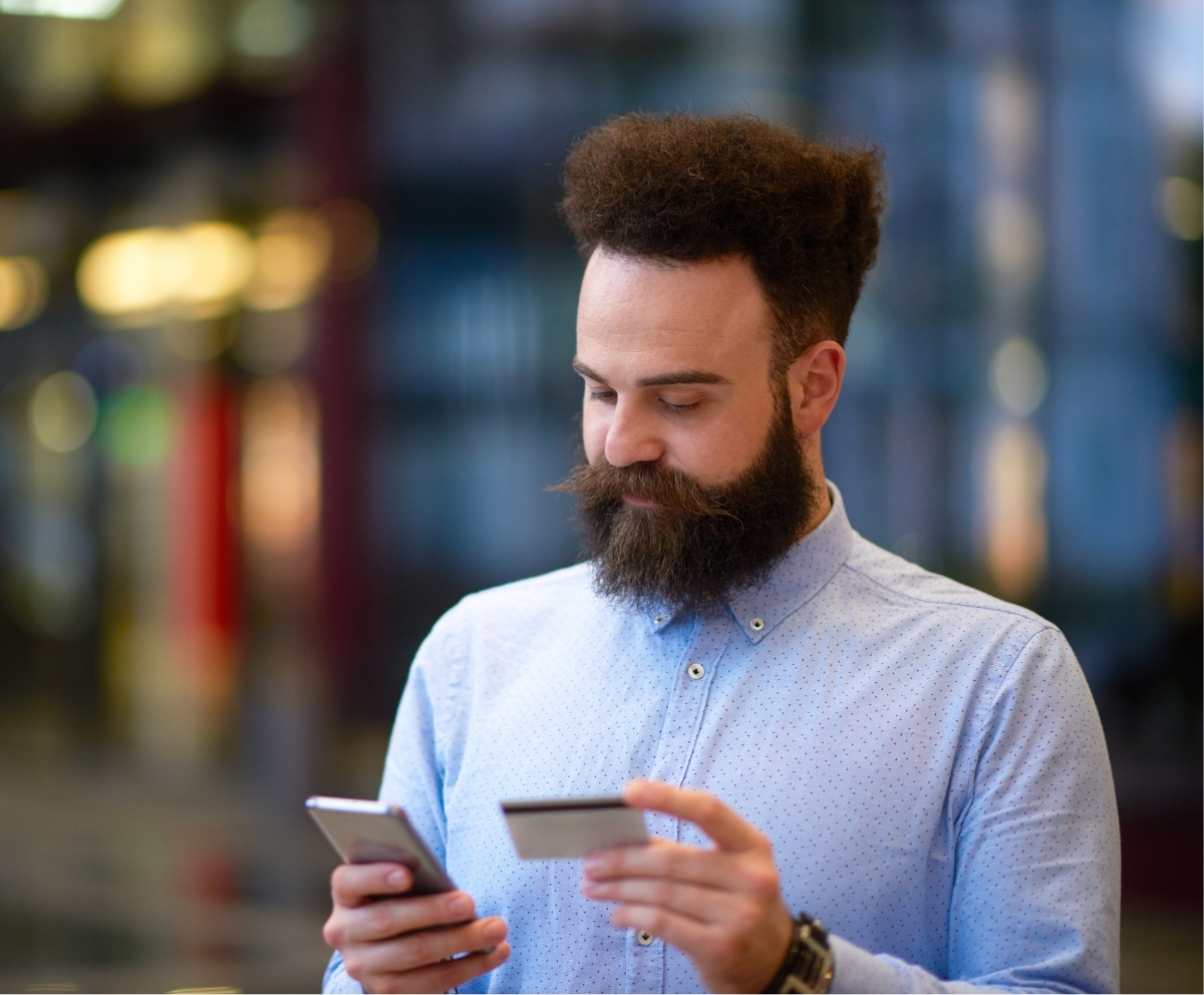Man using a smartphone and credit card for secure mobile wallet payments